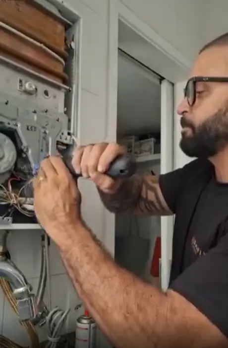 Técnico da Gás Fixe efetuando reparo nos queimadores de aquecedor a gás